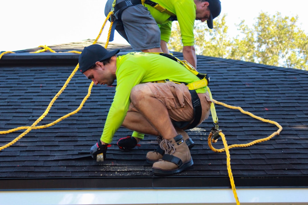 two-men-working-on-the-roof-of-a-house-rgknfjrpyo0